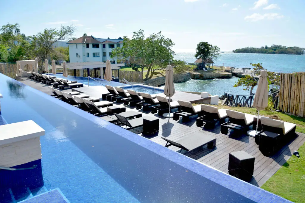 Infinity pool at Grand Lido Nude Luxury Resort Jamaica with ocean views and private sun loungers overlooking the Caribbean