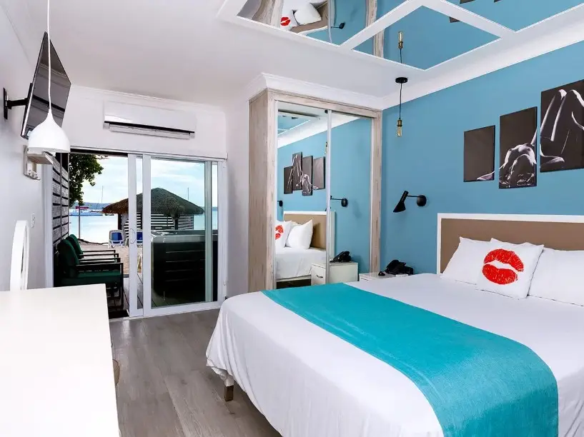 Premium room at Hedonism II resort in Negril Jamaica featuring king bed modern decor and glass shower