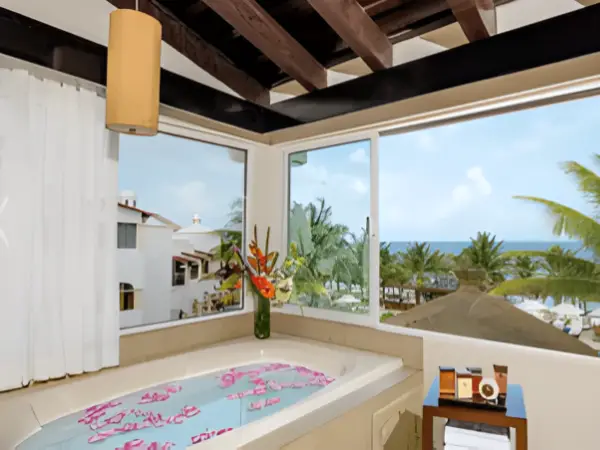 Spacious dome-style oceanfront suite at Hidden Beach Nude hotel takeover, featuring vaulted brick ceiling, hot tub, and Caribbean Sea view.