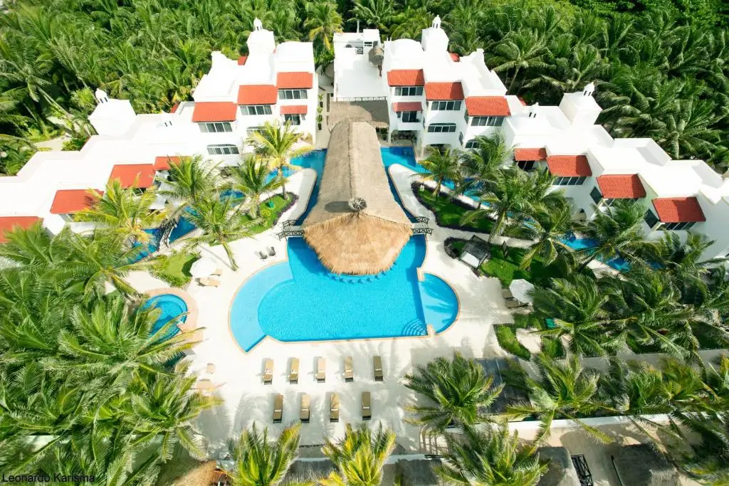 Aerial view of Hidden Beach Resort in Riviera Maya, Mexico, showing oceanfront nude resort layout surrounded by palm trees and pools for adults-only vacations.