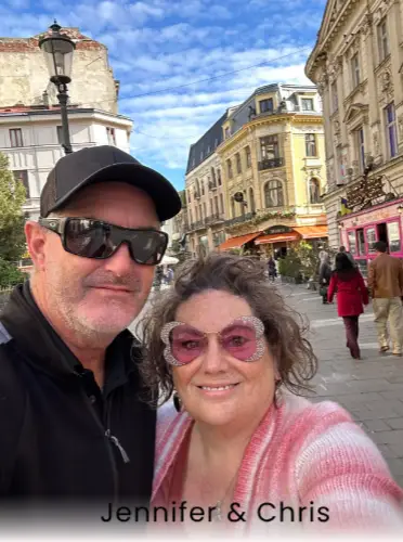 Jennifer and Chris, owners of Castaways Travel, experts in swinger, nude, and lifestyle travel. The couple is smiling while exploring a European city, representing the modern leadership, passion, and expertise behind Castaways Travel’s clothing-optional and couples-only vacations.