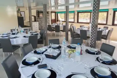 Elegant indoor dining room on the MV Majestic with panoramic windows and full table service, offering daily meals and the Captain’s Dinner on the Southern European Naturist Nude Cruise.