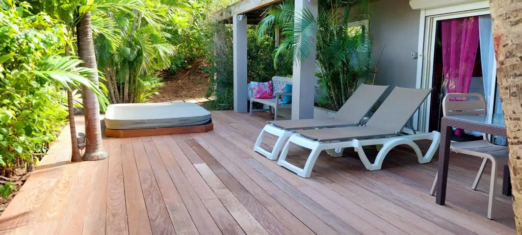 Private tropical terrace at Studio Pink with palm trees, sun loungers, and outdoor jacuzzi at a nude clothing optional Caribbean resort