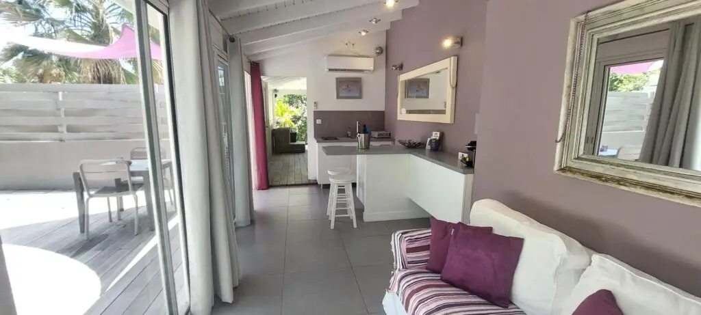 Open-plan kitchen and lounge with purple accents at Studio Purple, a clothing-optional Caribbean resort suite