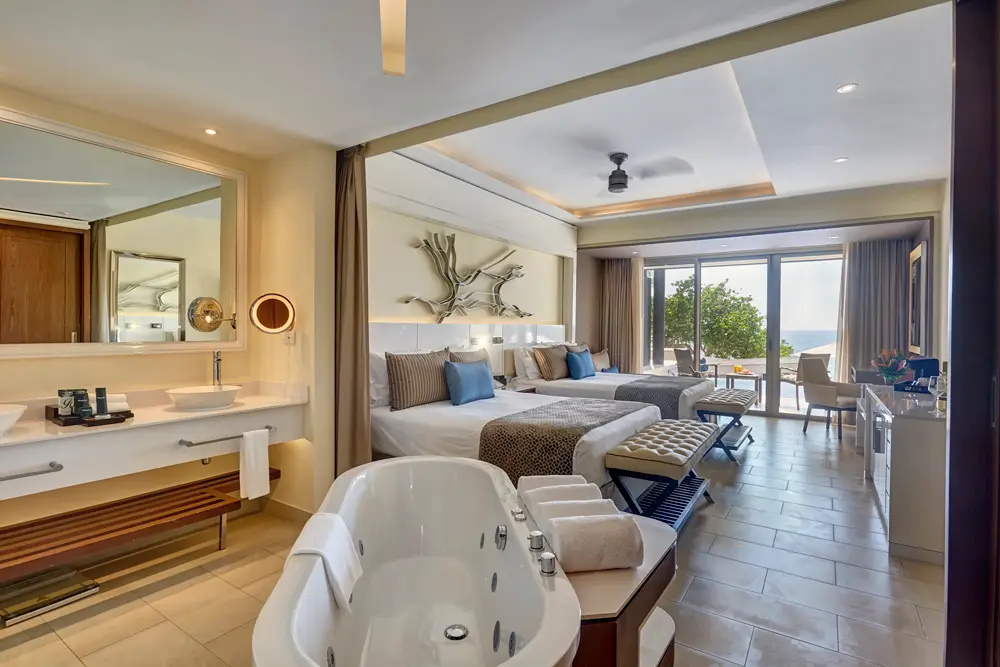 Sunset Swim-Out Suite at Grand Lido Jamaica nude luxury resort featuring dual queen beds, jacuzzi, and private pool access