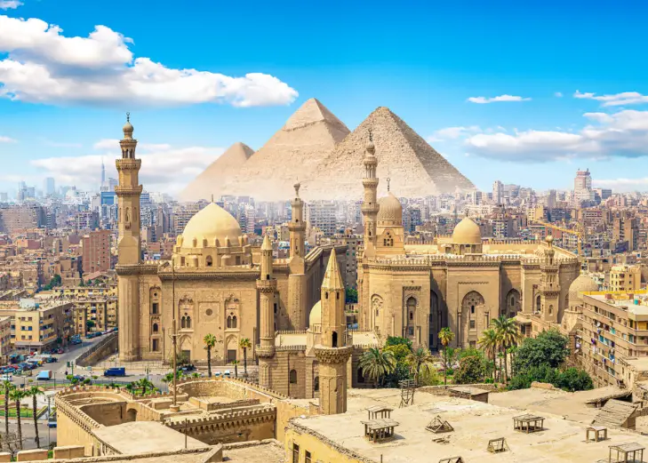Aerial view of Cairo Egypt with historic mosques and the Great Pyramids of Giza in the background promoting the LLV Egyptian Experience swinger cruise 2026