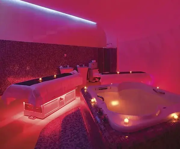 Spa Rosé hydrotherapy suite at Temptation Cancun Resort, an adults-only all-inclusive spa featuring jacuzzi and massage tables under romantic red lighting
