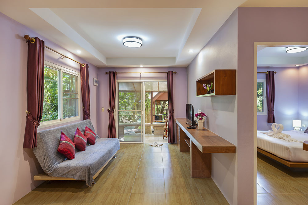 Spacious suite at Harmony Naturist Resort Phuket with living area, balcony view and bedroom