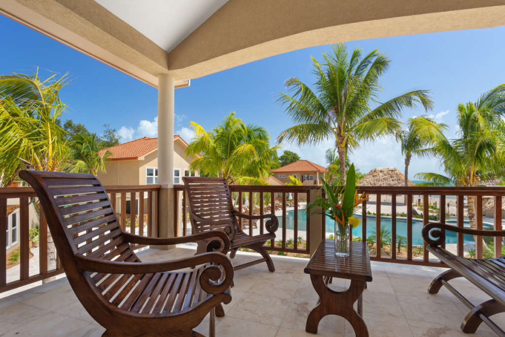 View from the Jellyfish Bungalow overlooking Sirenian Bay resort grounds, palm trees, pool and walkways during the Nude Takeover 2026 in Belize