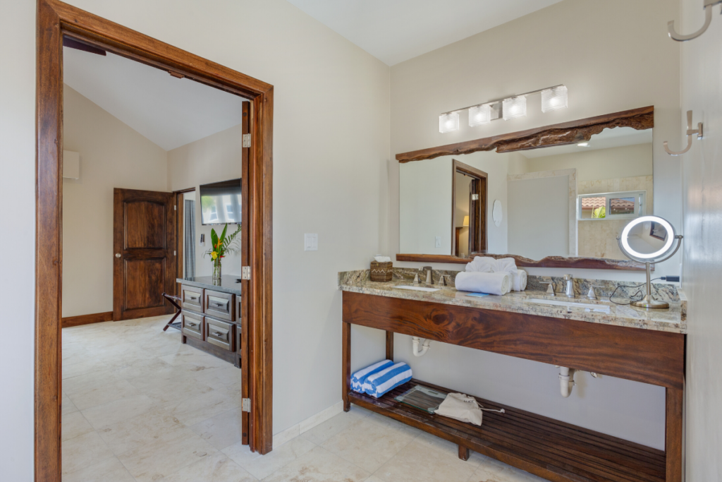 Modern spa style bathroom with double vanity, stone countertops, and custom wood mirror in the Jellyfish Bungalow during the Nude Takeover 2026 in Belize