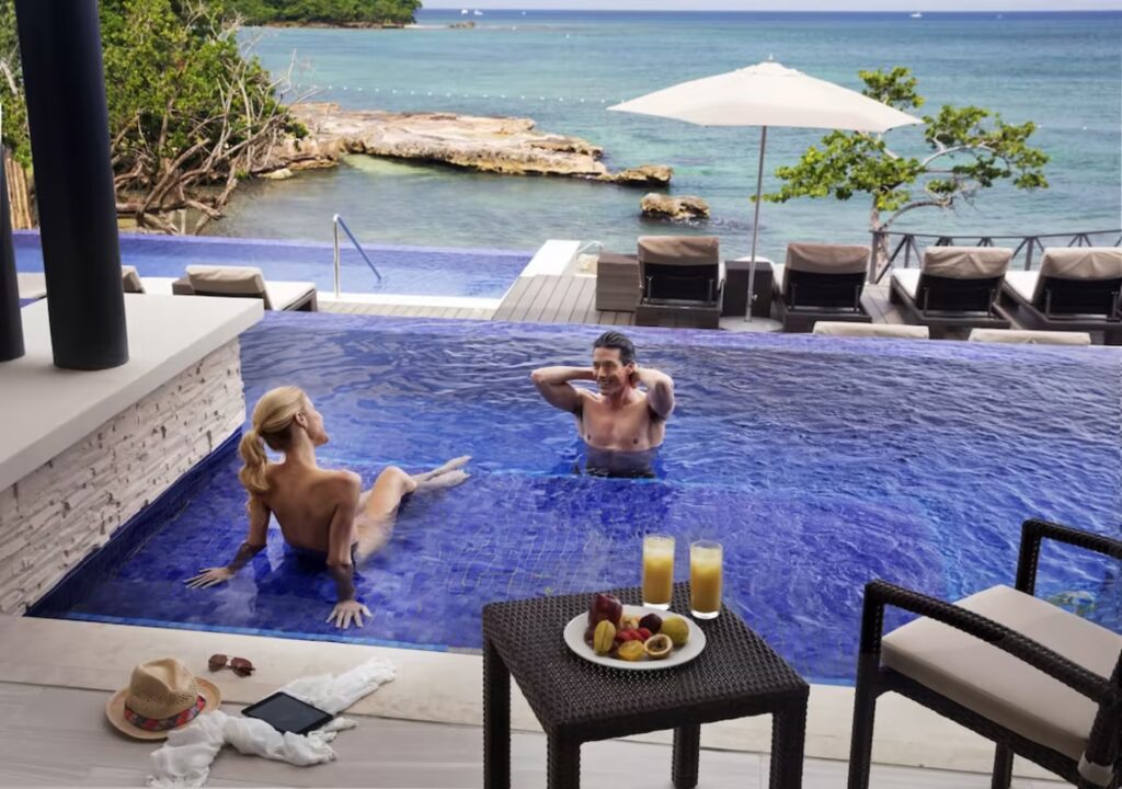 Couple at Grand Lido resort enjoying nude sunbathing in pool oceanside