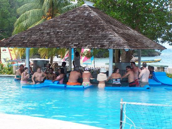 Guests socializing at Couples Sans Souci pool bar in Jamaica, adults only all inclusive resort for honeymoon and anniversary couples