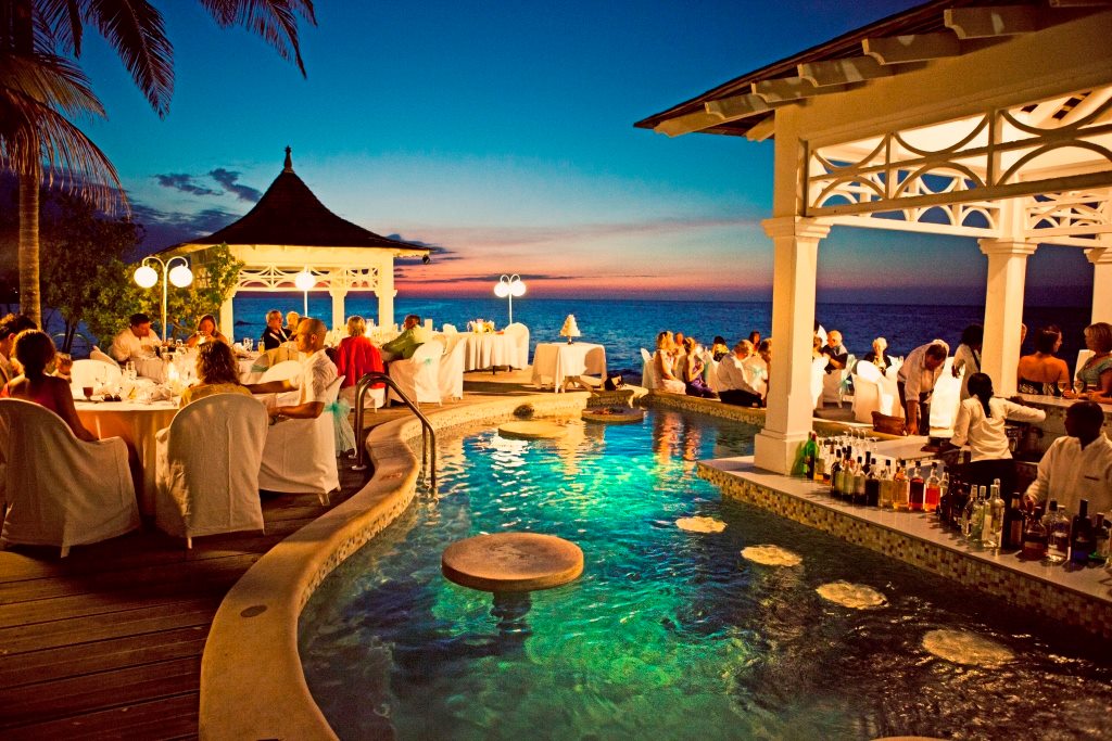 Couples enjoying romantic oceanfront dining at Couples Tower Isle Jamaica, adults only all inclusive honeymoon and anniversary resort