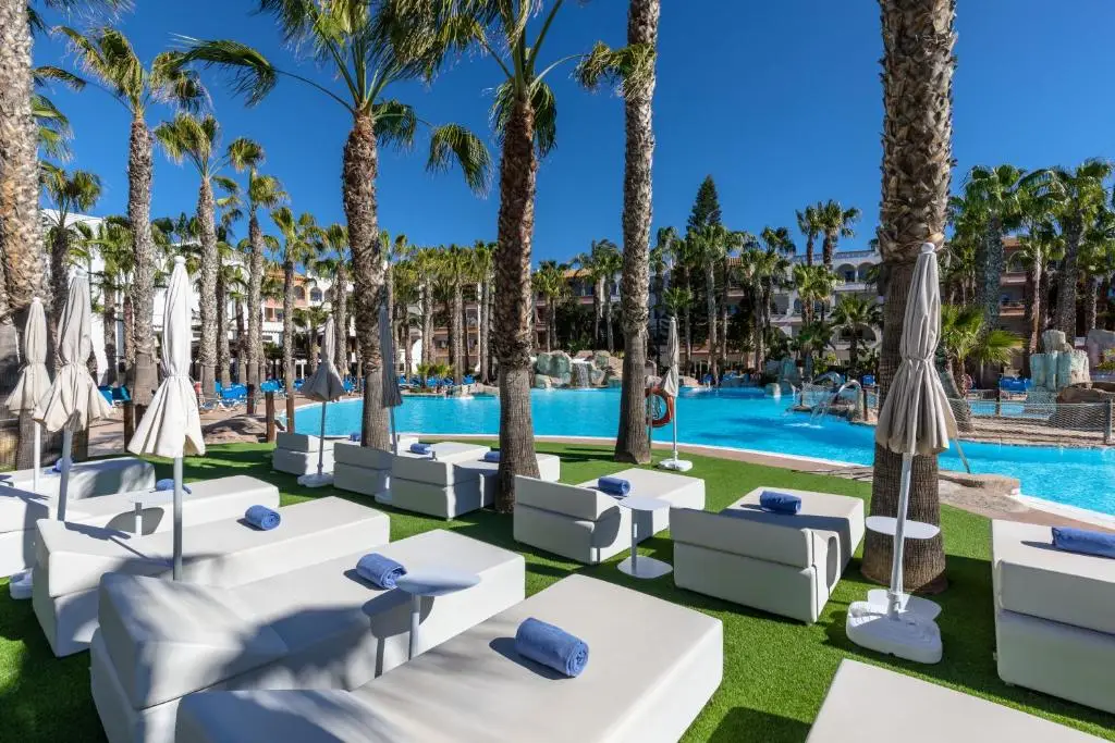 Nude resort Spain Vera Playa tropical pool area surrounded by palm trees and beachfront amenities