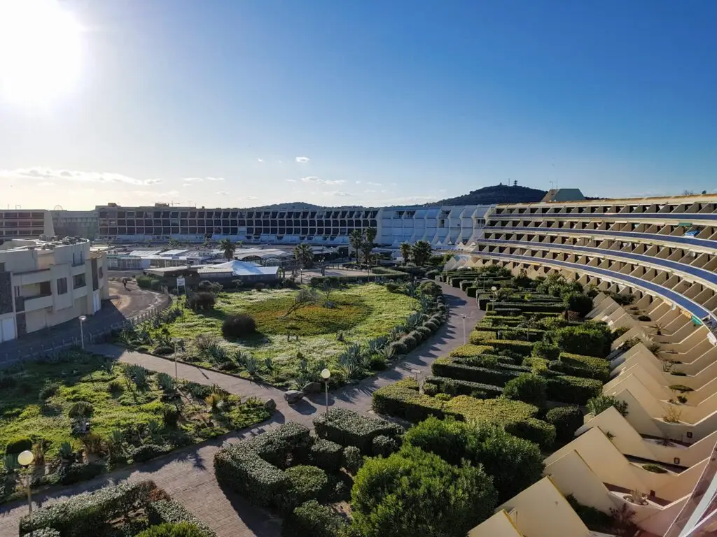 Heliopolis apartment complex in Cap d'Agde Nude City, France, offering accommodations surrounded by landscaped gardens near the naturist beach and village center.