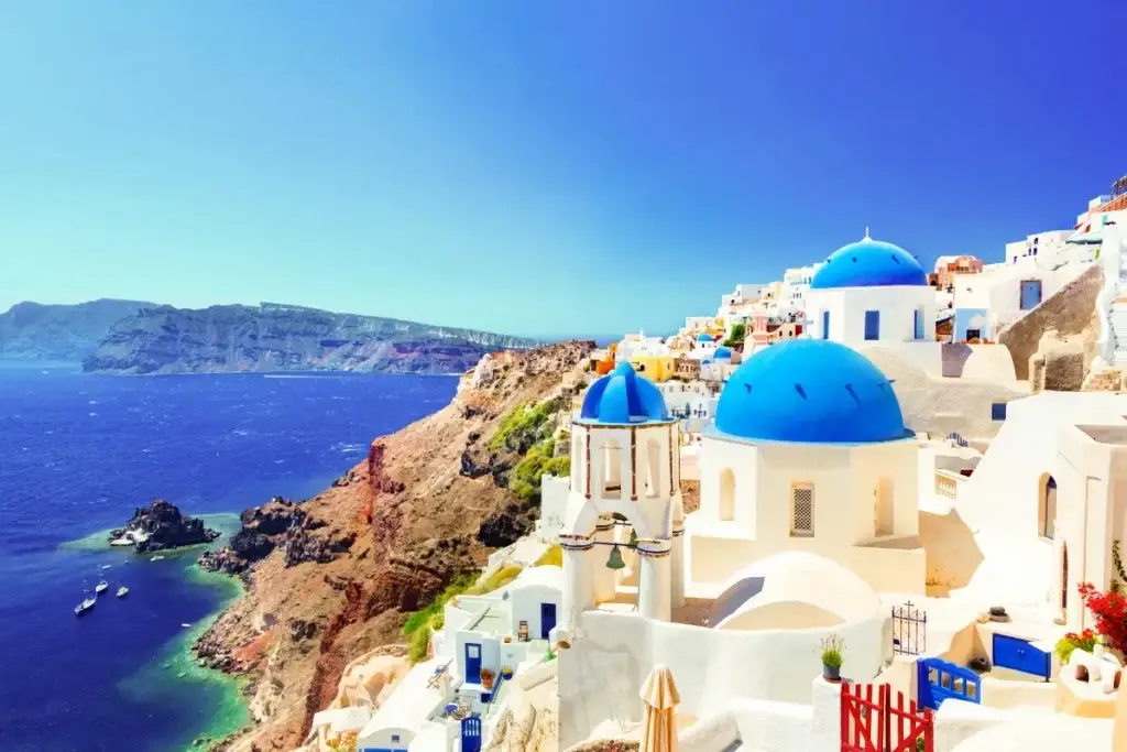Sunset overlooking Mykonos, Greece, with waterfront lounges and nightlife, featured on an adults only lifestyle group trip aboard Virgin Voyages Scarlet Lady.