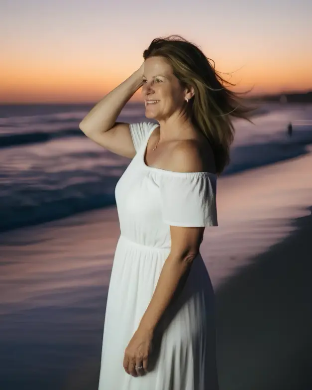 Swinger Cruise and Nude Travel Expert on the beach in white dress